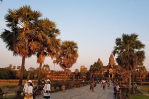 Angkor Wat at sunset hours with the tourist visiting. The golden hours moment reflection to the Angkor Wat look so gold.